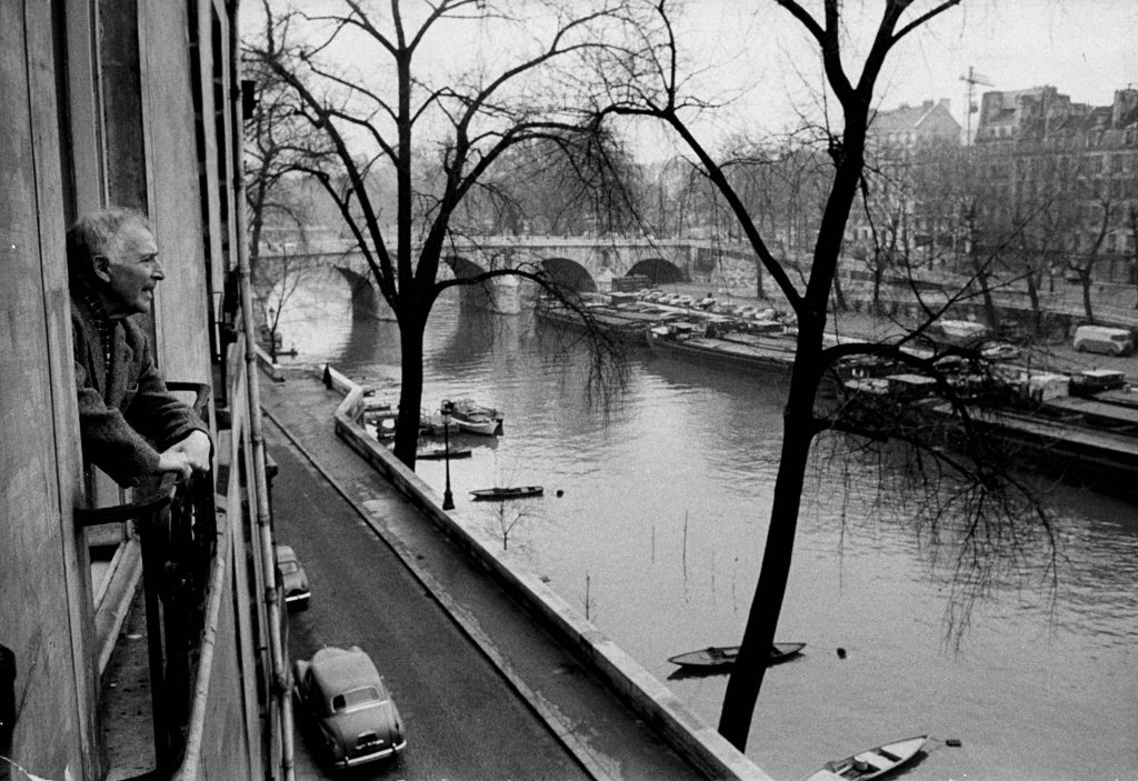 Chagall looking out over the river Seine from the window of his home in Paris
