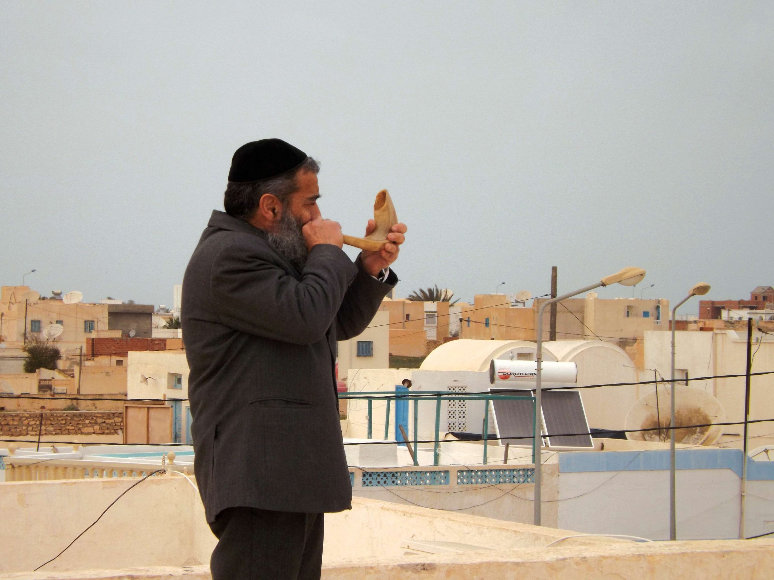 An ancient custom continues on the rooftops of Djerba. Rabbi Chaim Biton with his shofar