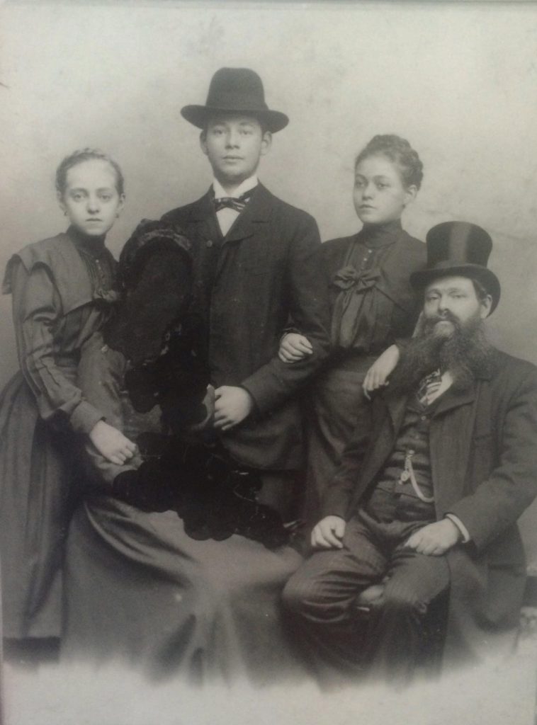 אריה שטיינברגר עם שלושת ילדיו, רגינה, סלומון וגיזלה, סביב 1900. דמות נוספת בתמונה, כנראה אם המשפחה, נמחקה במכוון בכתם דיו שחור מסיבה לא ברורה. האם והבת גיזלה נפטרו בזו אחר זו בהפרש של שנה