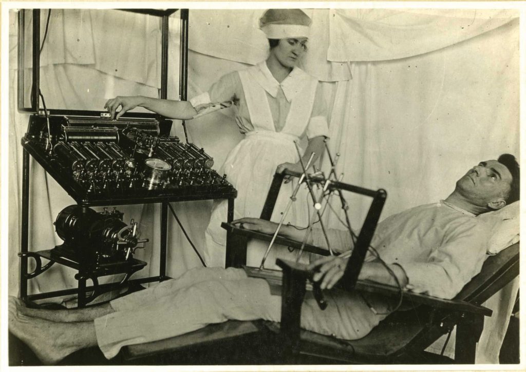 A nurse treats a shell-shocked soldier with electric shocks