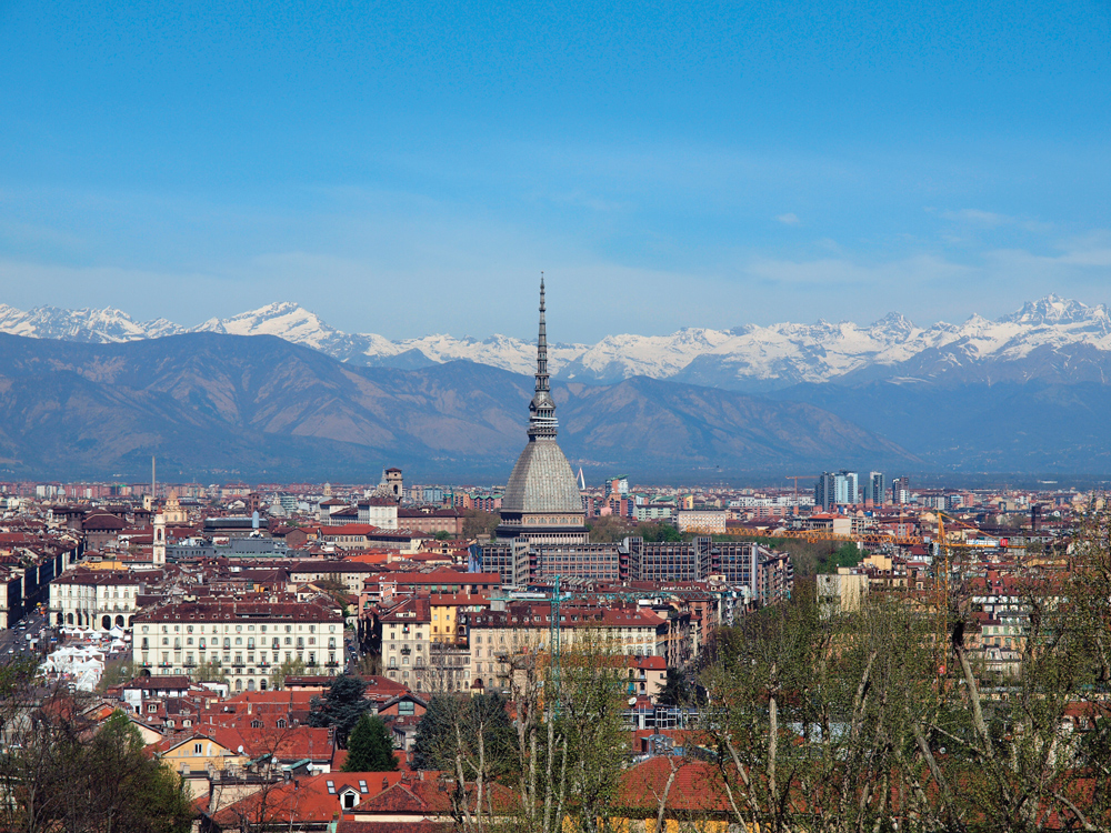 Turin, an Italian city in the foothills of the Alps. The soaring spire dwarfing the church to its left belongs to the Mole Antonelliana, originally designed as a synagogue