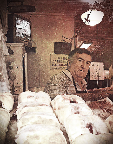 Well known baker Alex Wolfman standing with his wares in the window of Yonah Schimmel's bakery in the Lower East Side. The bakery has been selling knishes since 1890