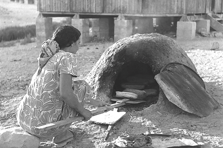 Moroccan immigrant baking bread in an outdoor oven in Yeruham, 1956