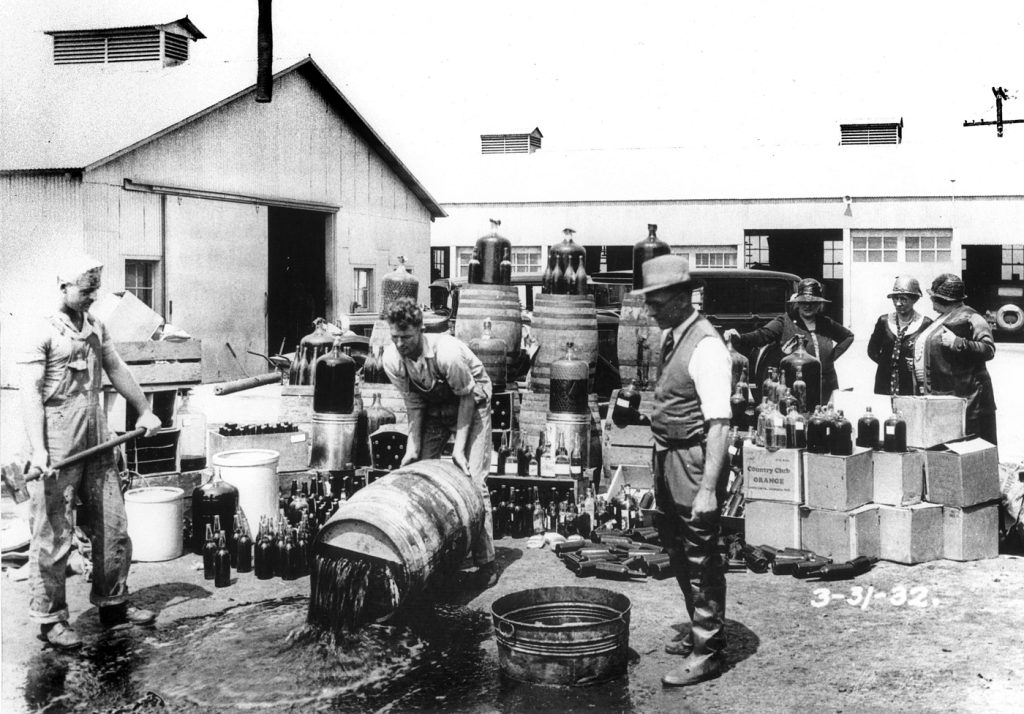 שוטרים ממחוז אורנג' שופכים אלכוהול שהוכן במזקקה בלתי חוקית. סנטה אנה, מרץ 1932