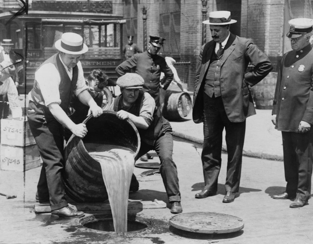 שוטר משגיח בזמן שאלכוהול מוחרם נשפך ברחובות העיר ניו יורק, 1921