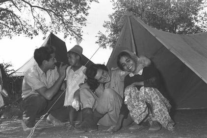 Two soldiers entertain immigrant children at a transit camp in Kisalon, December 1950 