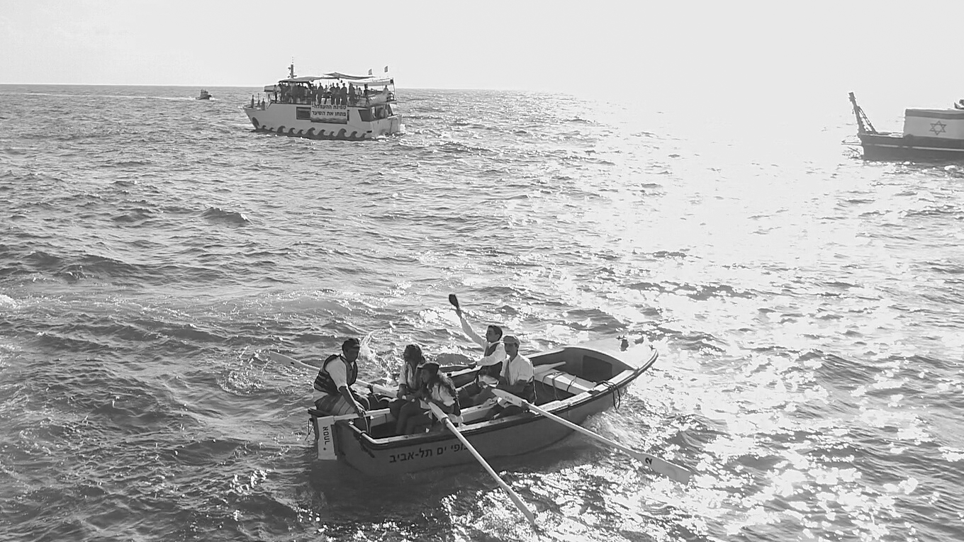 Dressed for the part, re-enactors playing illegal immigrants prepare to disembark at Tel Aviv beach