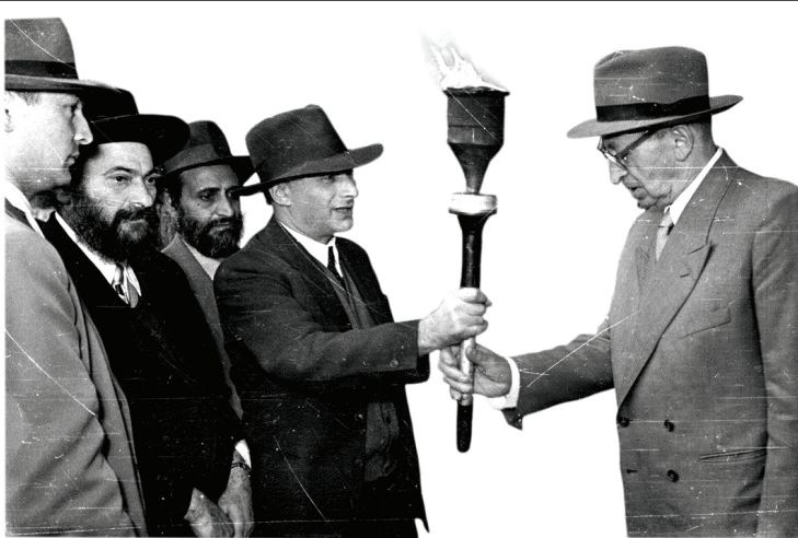 On Hanukka, a Ministry of Religious Affairs delegation led by S. Z. Kahane hands President Yitzhak Ben-Zvi a torch lit at the Beacon in Modi’in 