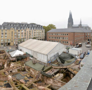 Excavations outside Cologne’s town hall reveal the city’s Jewish and Roman past. The mikveh is beneath the pyramid-shaped roof at left; the medieval synagogue was under the white tent | Photo: Christina Kohnen, Cologne Municipality