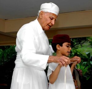 Zoroastrians wear a white tunic (sedreh) and girdle (kushti) as undergarments to protect them from evil thoughts. Ceremonial tying of a kushti | Photo: Tyabji